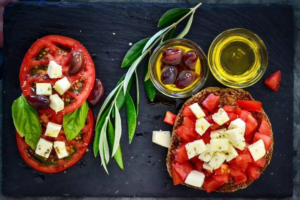 dakos, tomato, olives, olive oil, branch, leaves, plating, cheese, oregano, basil, mediterranean, vegetarian, diet, healthy, vegetables, fresh, tomatoes, red, starter, salad, green, nature, snack, italian