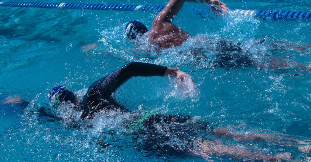 Two swimmers competing in an outdoor pool, showcasing speed and skill.