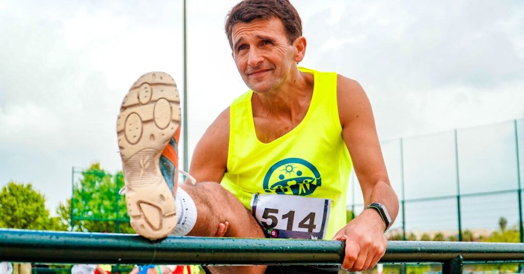 Senior man stretches before outdoor track run. Bright day for fitness.