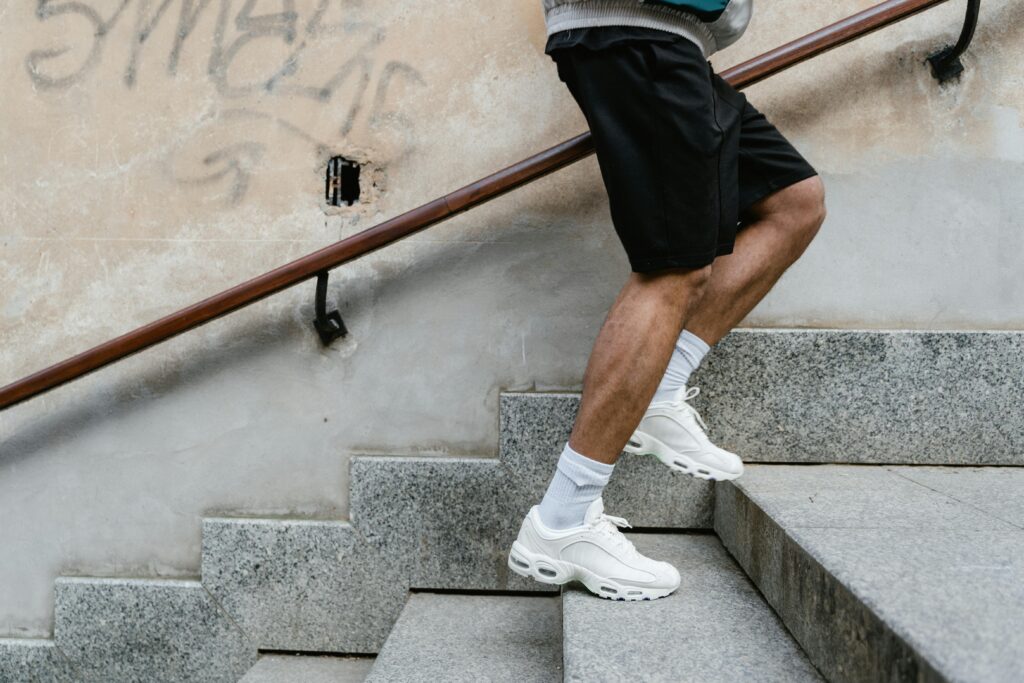 pexels-photo-7879922-7879922 Adult male in athletic attire climbing stairs outdoors, emphasizing fitness and energy.