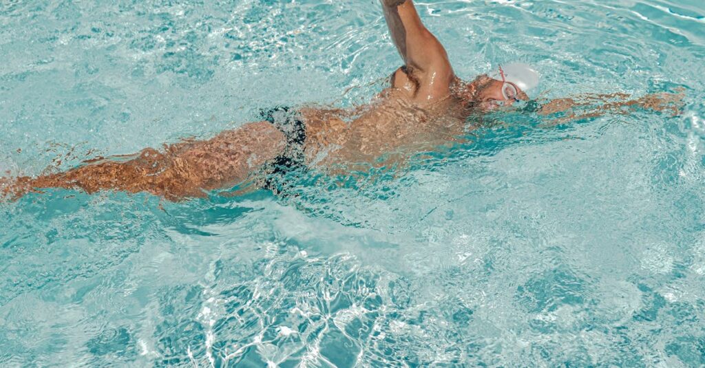 Male swimmer in action practicing freestyle swimming in a clear pool.
